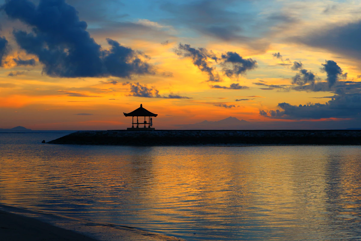 Peaceful sunrise bicycle boardwalk and calm barrier reef shallows in Sanur