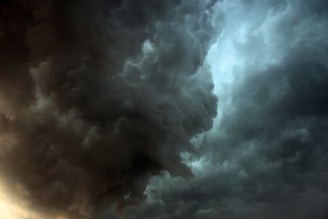 Dark, swirling storm clouds dominate the sky, creating a dramatic and intense atmosphere. The clouds are dense and textured, with areas of lighter and darker shades, suggesting impending heavy rain or a thunderstorm.