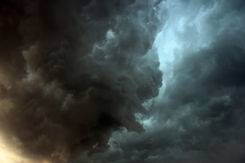 Dark, swirling storm clouds dominate the sky, creating a dramatic and intense atmosphere. The clouds are dense and textured, with areas of lighter and darker shades, suggesting impending heavy rain or a thunderstorm.