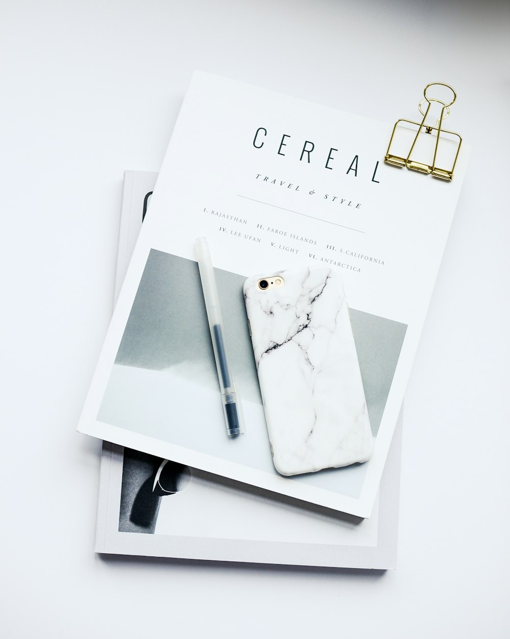 a magazine with a marble cover and a pen on top of it
