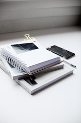 A stack of neatly organized papers with a red pen on top.