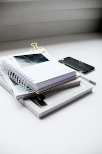 A neat stack of colorful study materials and notes arranged on a clean desk.