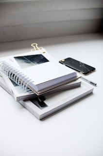 A stack of neatly organized printed templates next to a digital tablet.