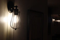 A night scene with a warm-lit hallway showcasing the soft glow of rattan shade sconces.