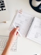 person holding notepad and pen flat lay photography
