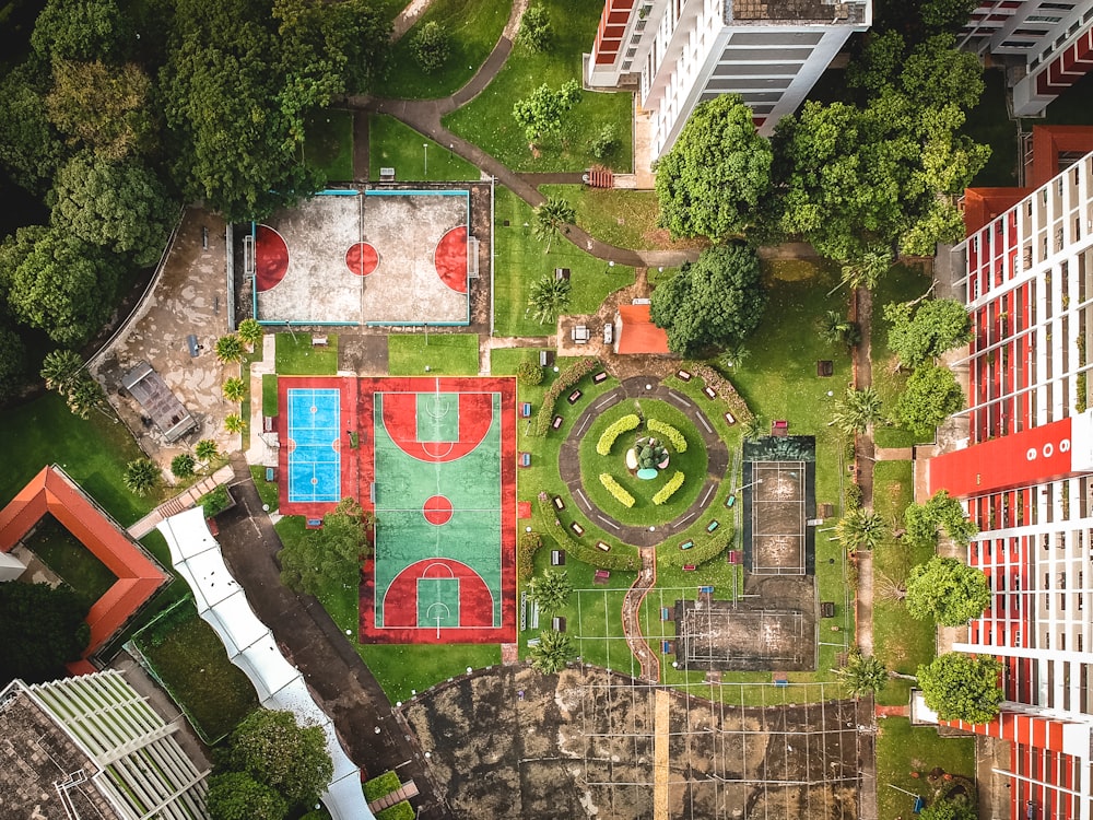 Photographie de vue de dessus de deux terrains de basket-ball à côté d’un bâtiment en béton pendant la journée