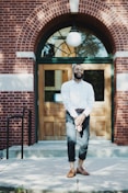 man standing in front of brown wooden door during daytime