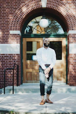 A business owner standing proudly in front of their storefront.