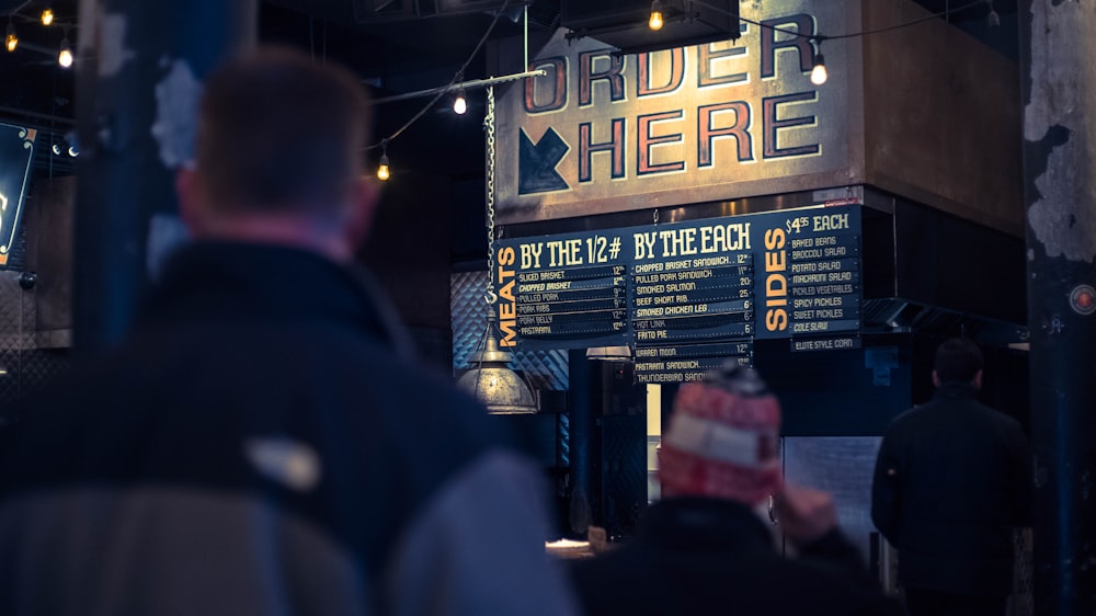 selective focus photo of person standing near store sign