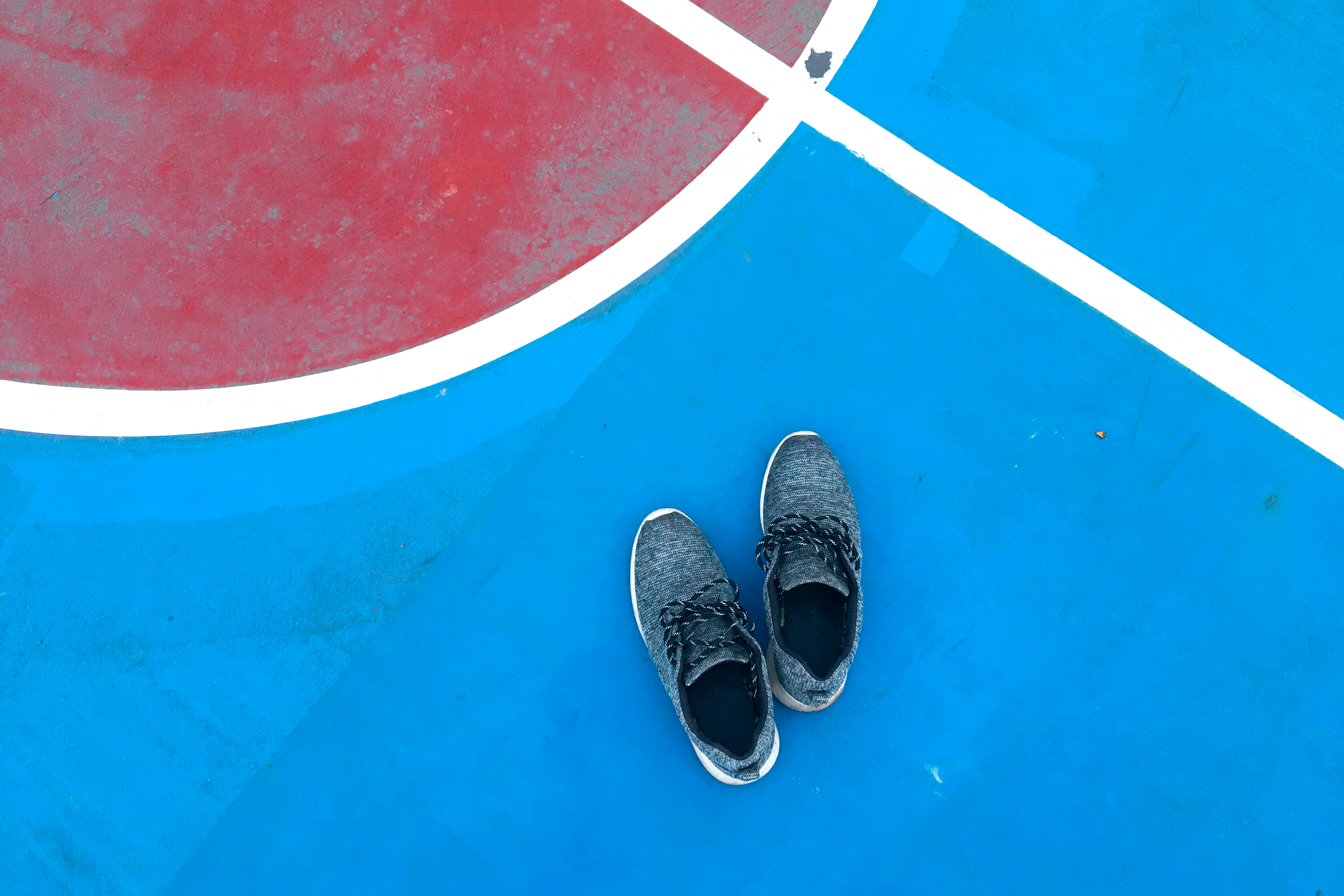 pair of blue shoes on ball court