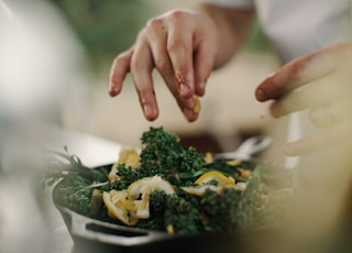 selective focus photography of green and orange vegetables on black container