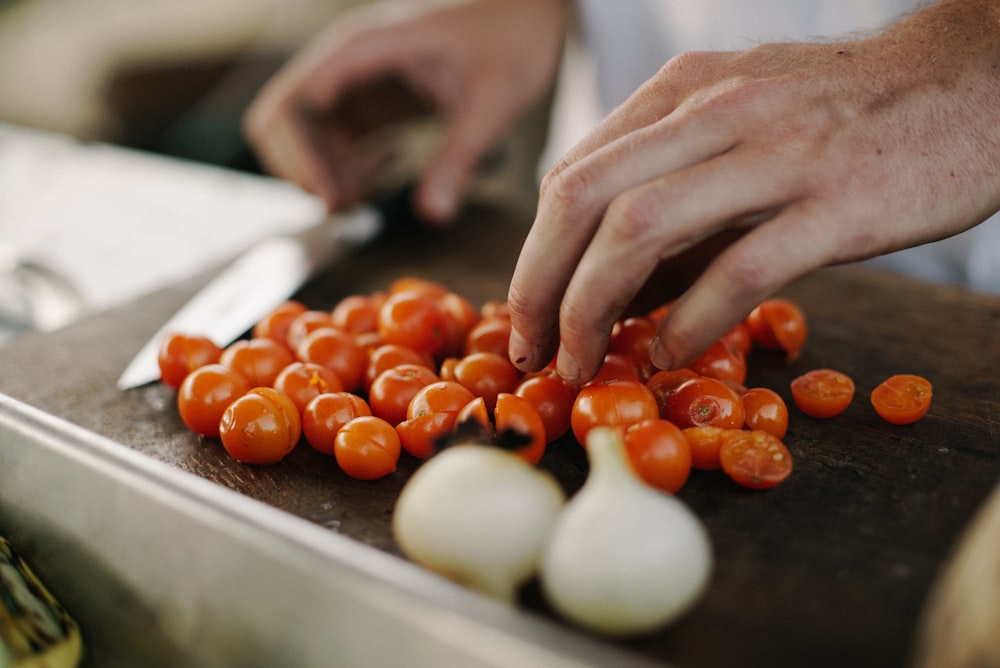 person slicing cherry tomatoes