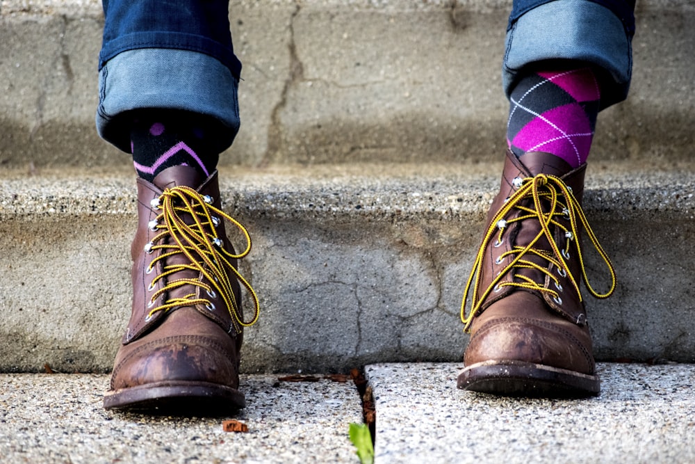 Person in braunen Wildlederstiefeln und rosa Socken