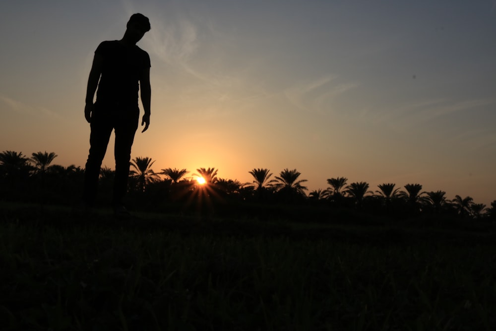 silhouette photo of man standing on ground