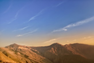 A serene Himalayan mountain landscape with sunlight highlighting wild honeybees and shilajit deposits on rocks.