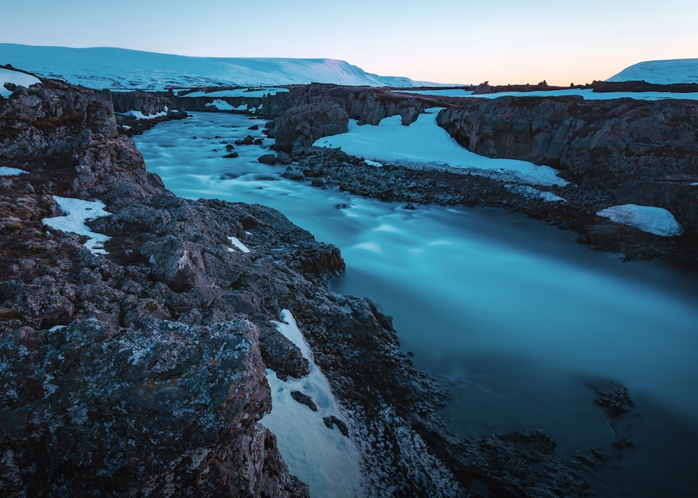 time lapse photo and aerial view of river surrounded by rocky mountains