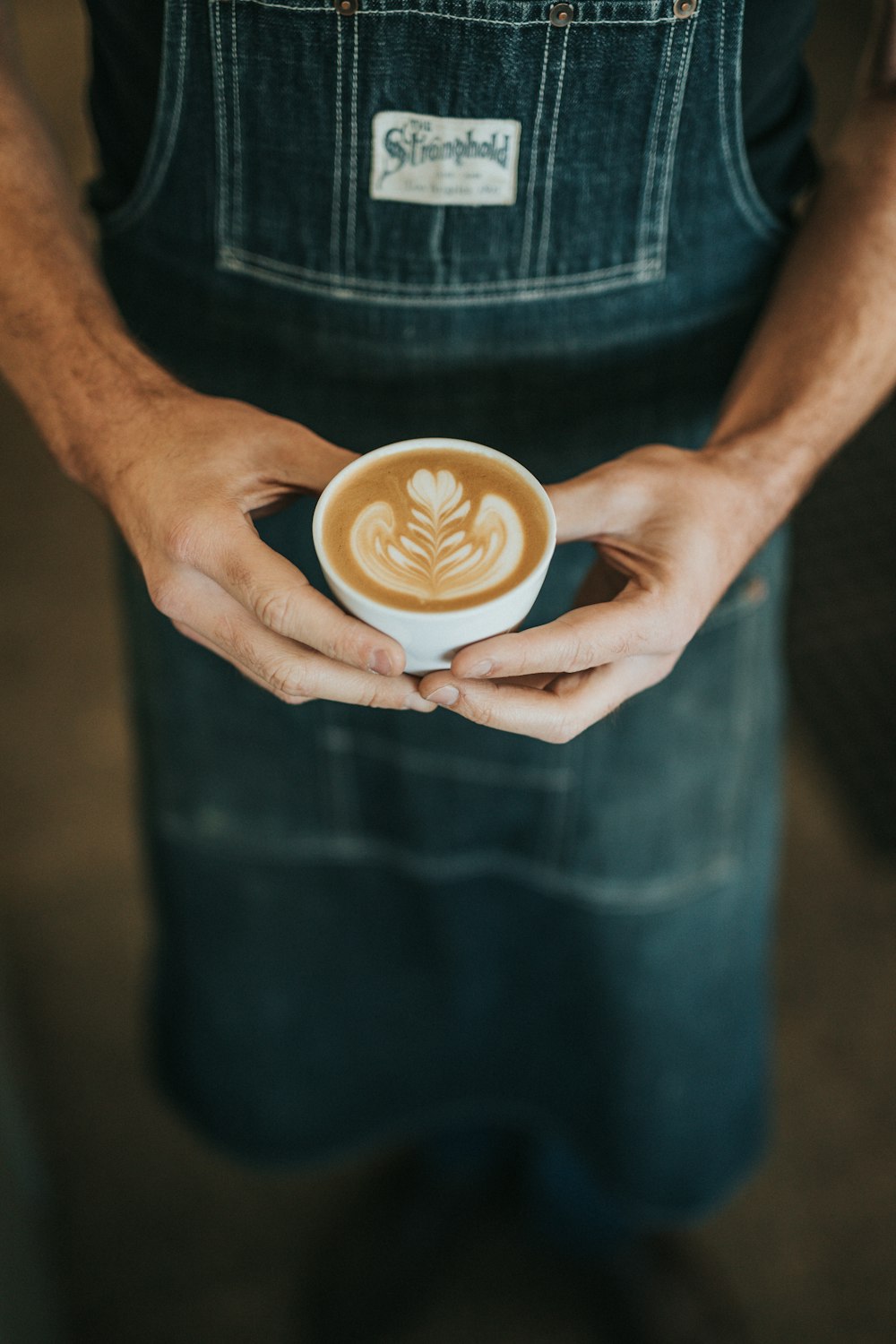 Persona sosteniendo una taza de café con leche