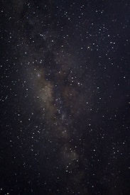 A vast expanse of a starry sky showcasing intricate clusters and dense sections of stars. The image captures varying intensities of starlight against a deep, dark background, suggesting a view of the Milky Way galaxy.