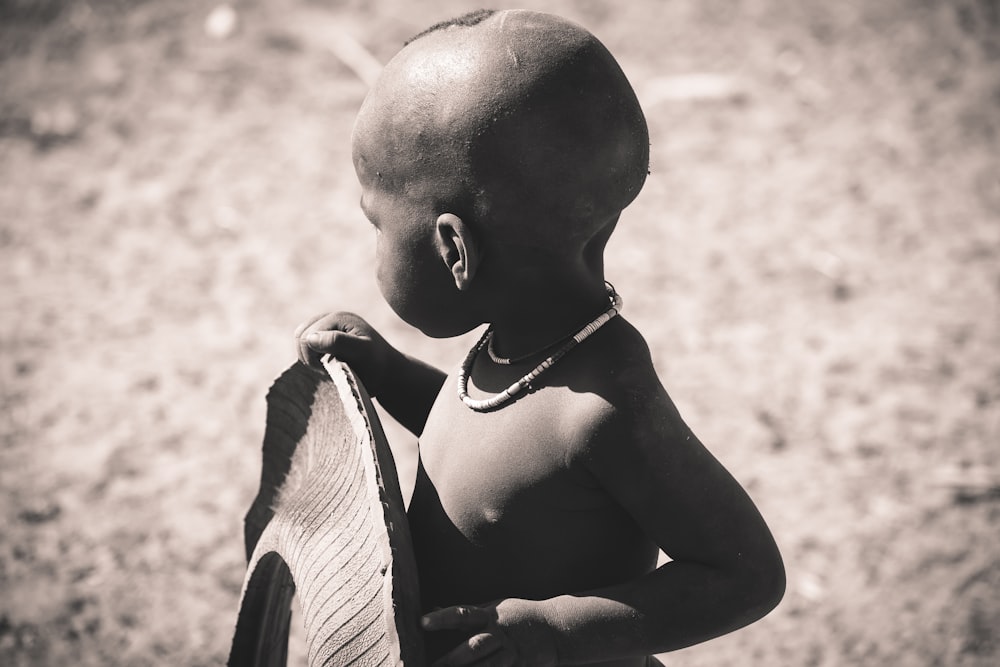 grayscale focus photo of children holding tire