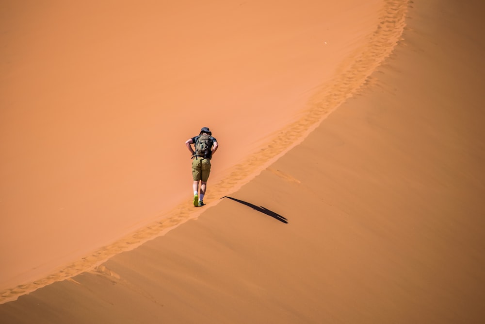 person walking on sand cliff