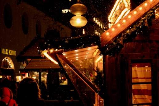 A warmly lit Christmas street scene in Moralzarzal with festive decorations and happy people.