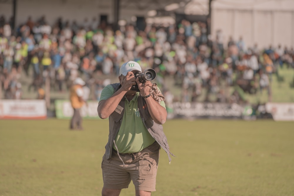 man holding camera near sports field