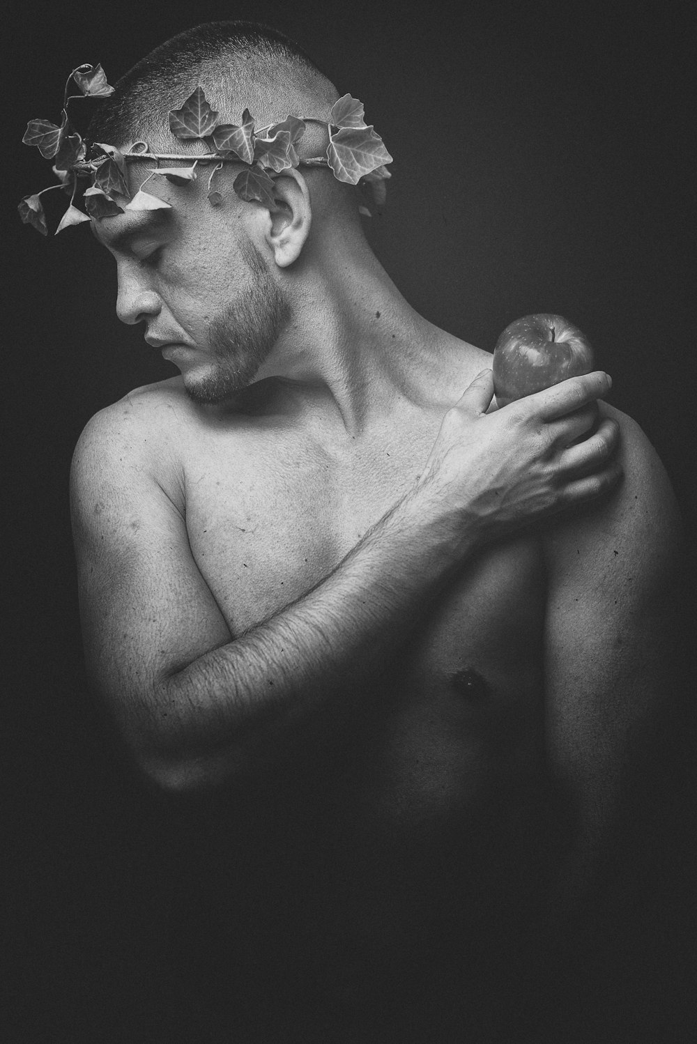 grayscale photo of man holding apple fruit