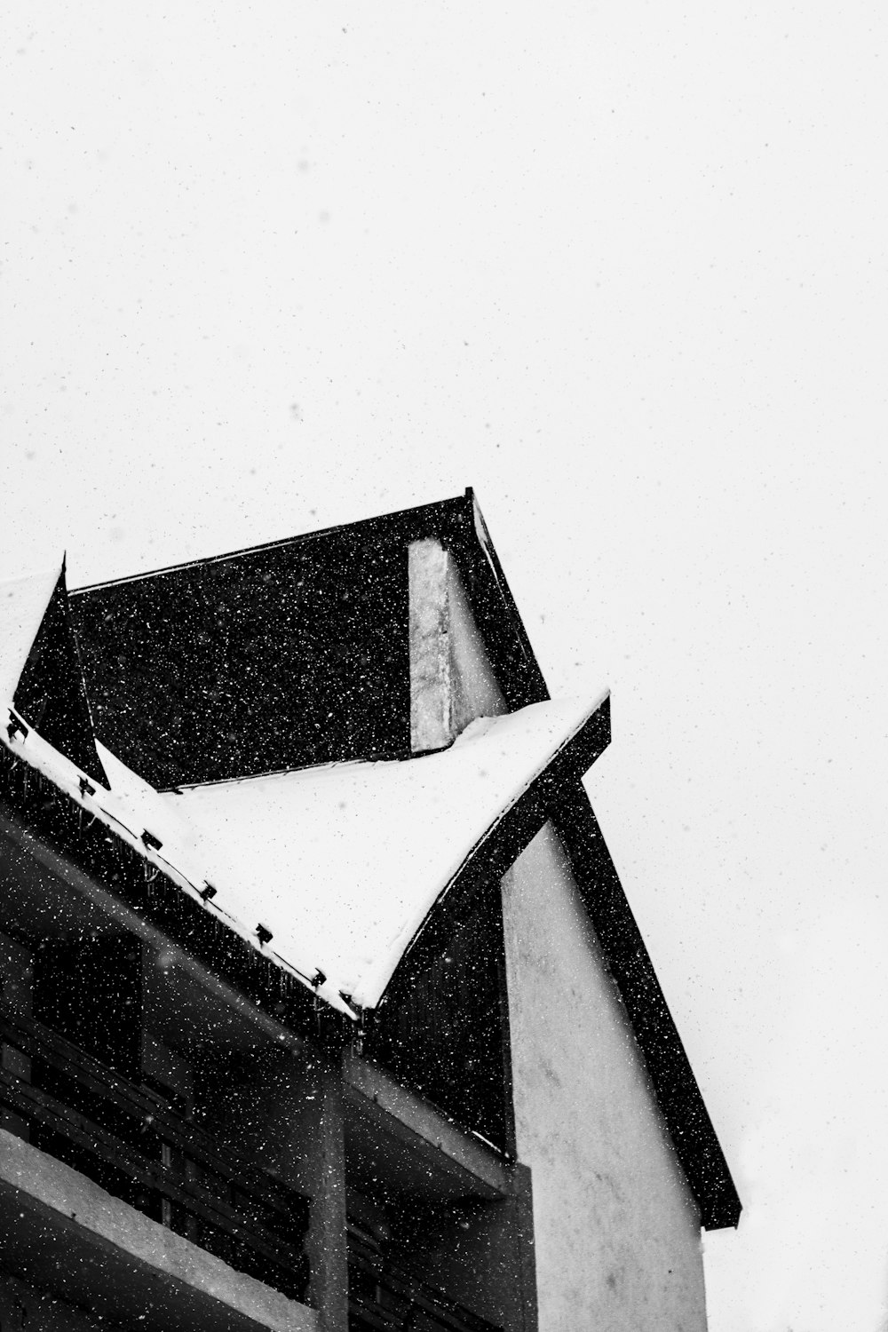 Una foto in bianco e nero di un edificio con la neve sul tetto