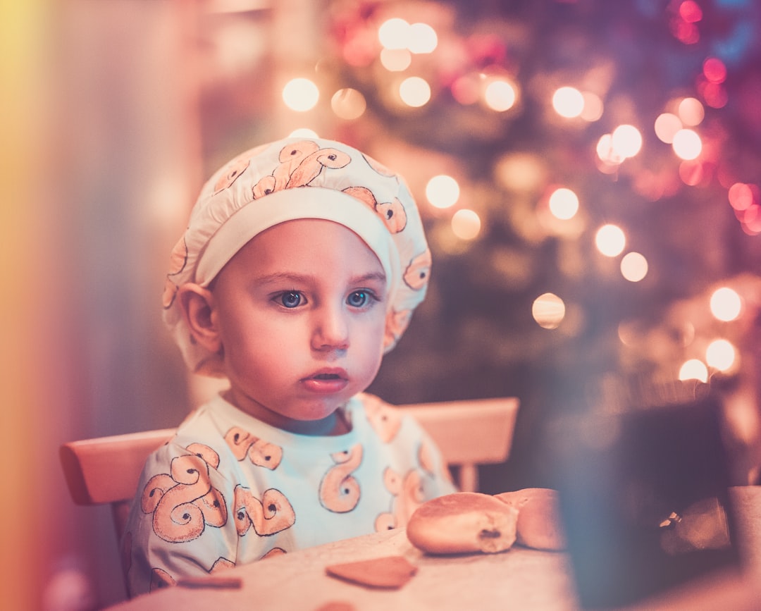 baby sitting next to a table with bread