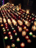 Elegant row of Candesso candles in distinctive artisanal containers displayed on rustic wood.