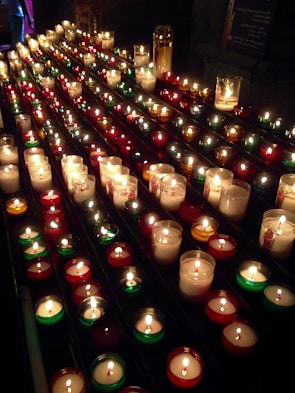 Rows of white votive candles neatly arranged ready for wholesale packaging.