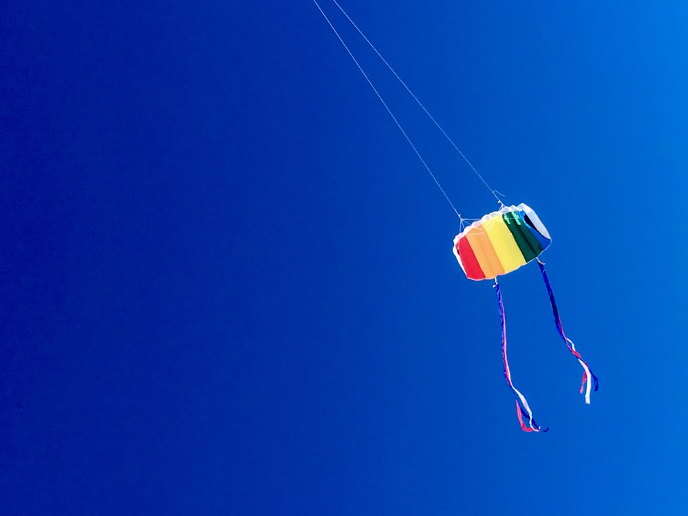 multicolored kite under blue sky at daytime