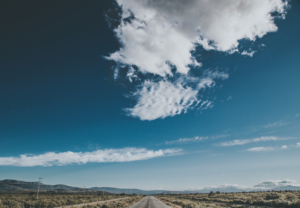 gray road under cloudy sky