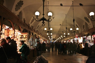 Brightly lit Eisenbahnhalle filled with visitors exploring various artisan booths.