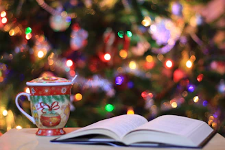 red and green ceramic mug beside book