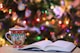 red and green ceramic mug beside book