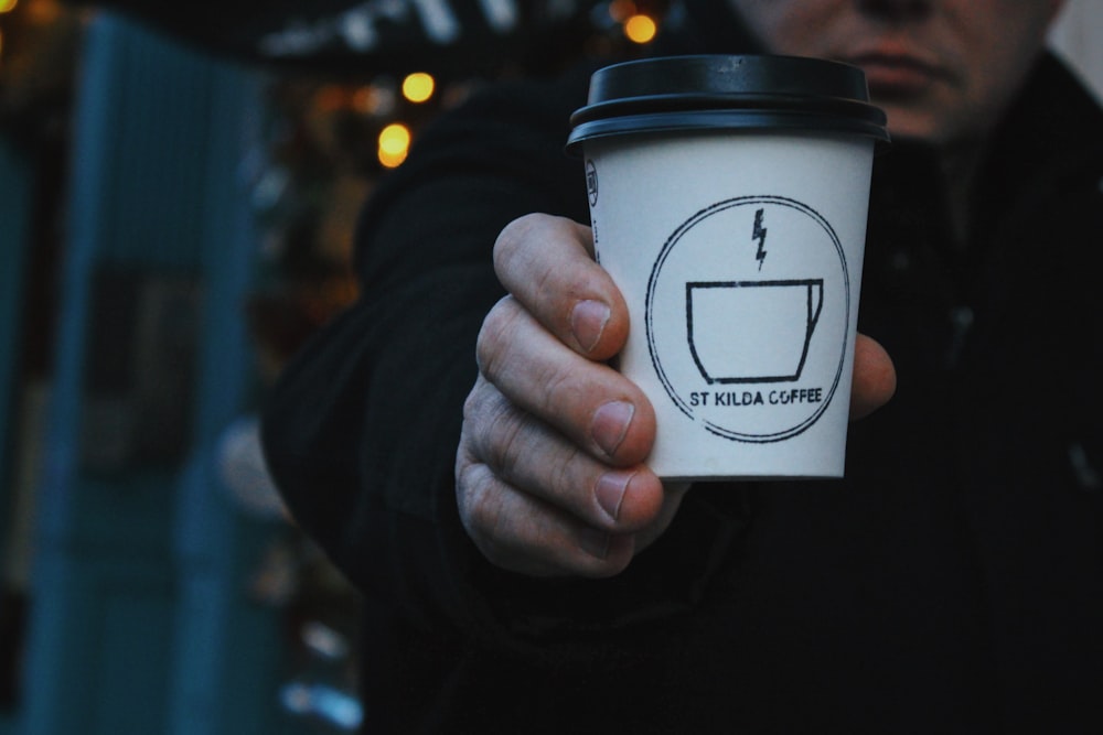 a man holding a cup of coffee in his hand