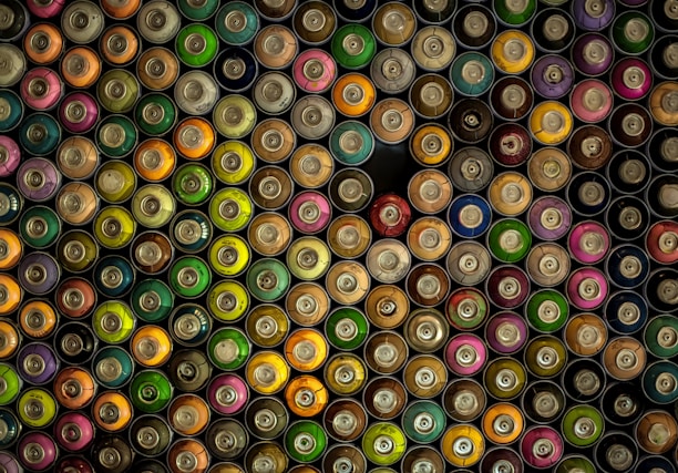 A close-up of colorful paint cans arranged neatly on a workbench, showcasing vibrant hues.