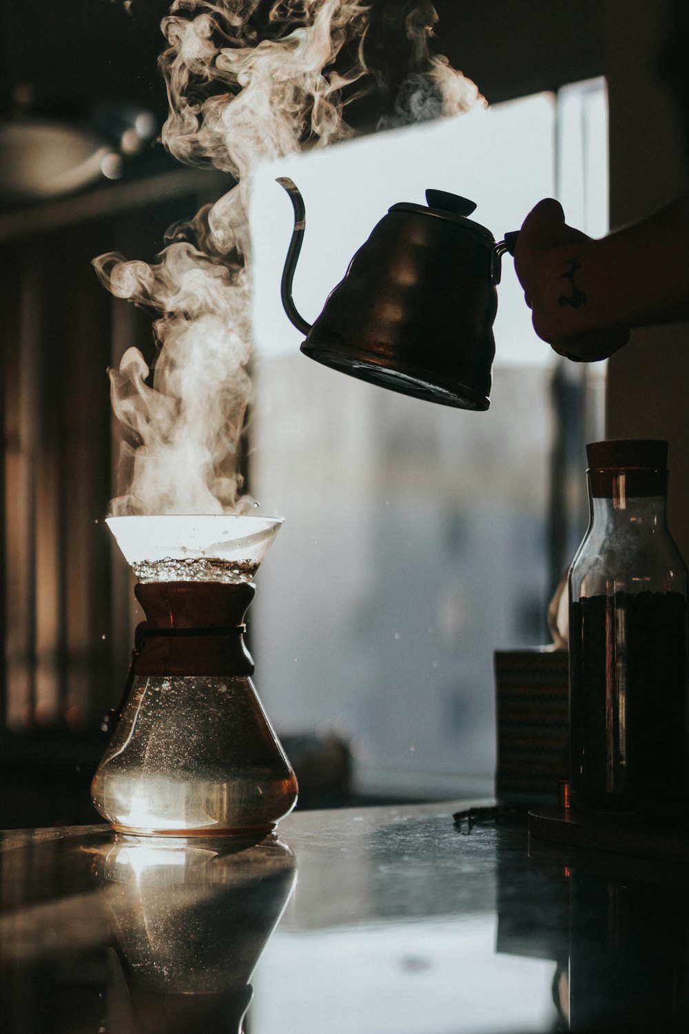 person holding teapot with boiled water