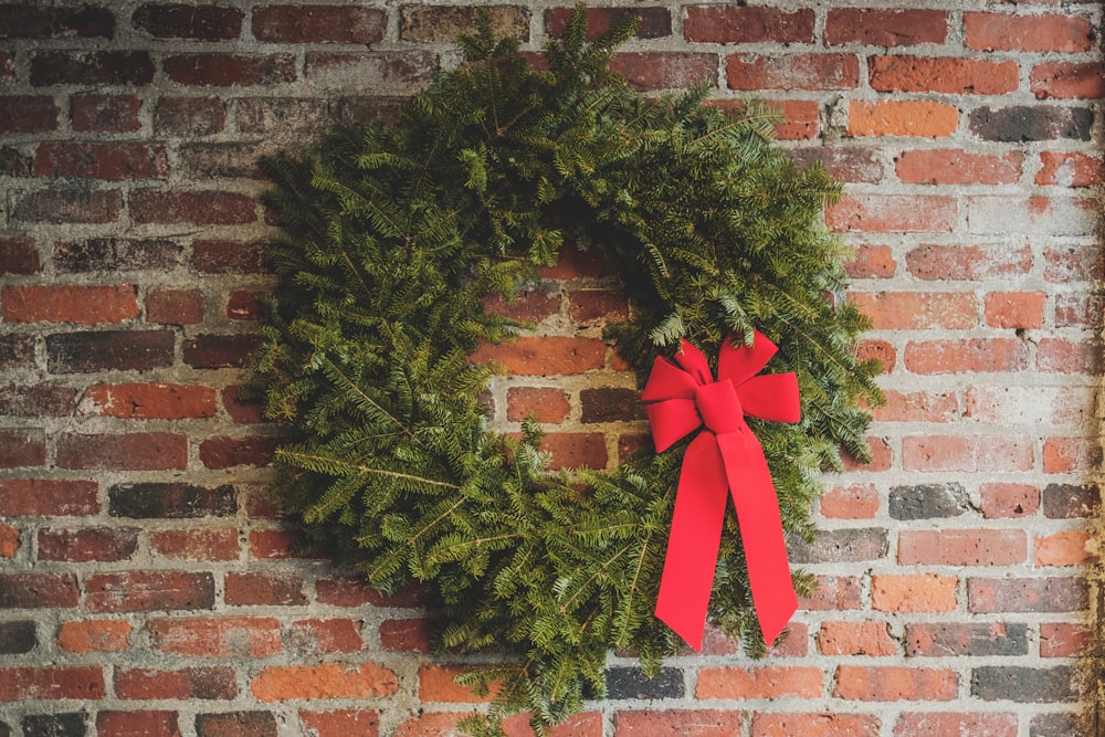 green wreath hang on wall brick