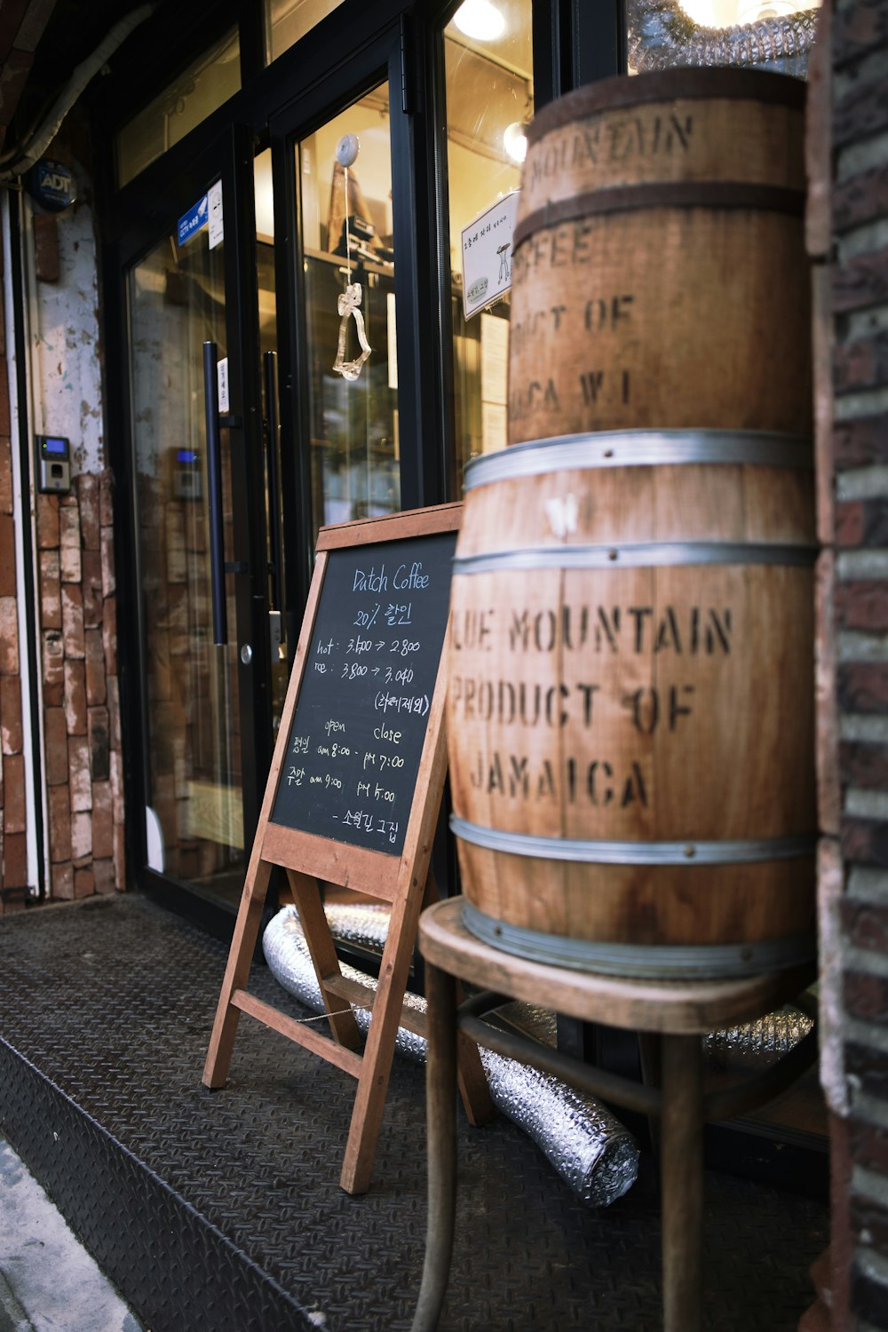 brown and black signboard beside two brown wooden barrels