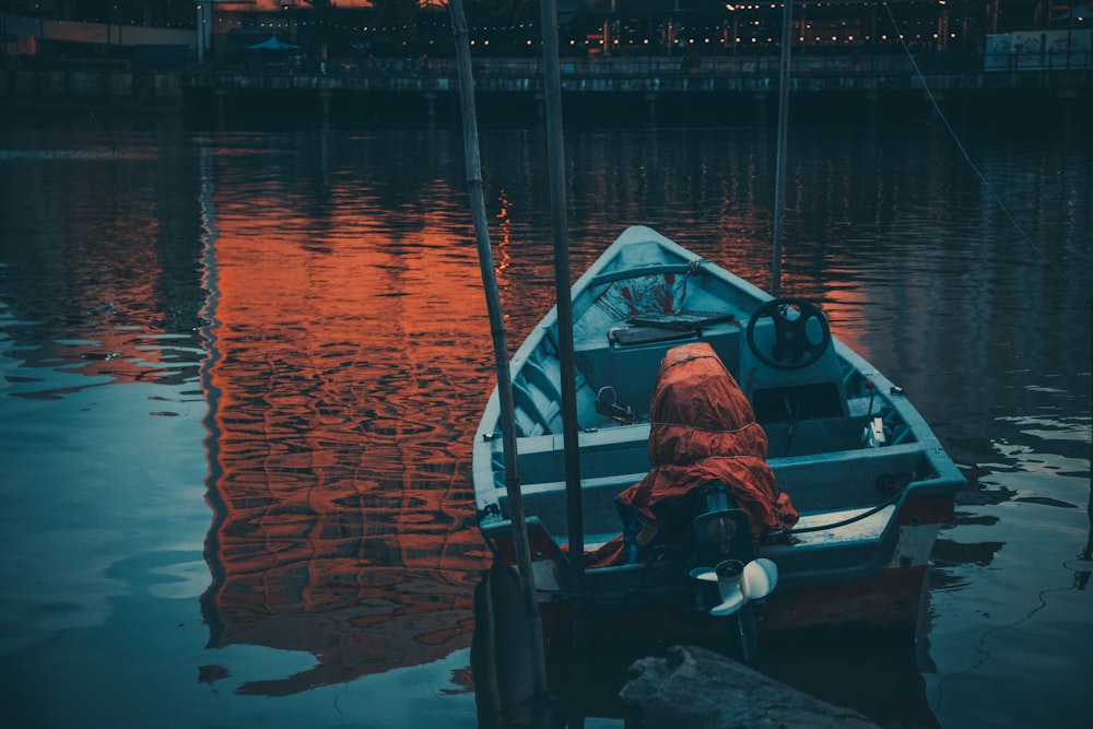 gray and orange motorboat on water during dusk