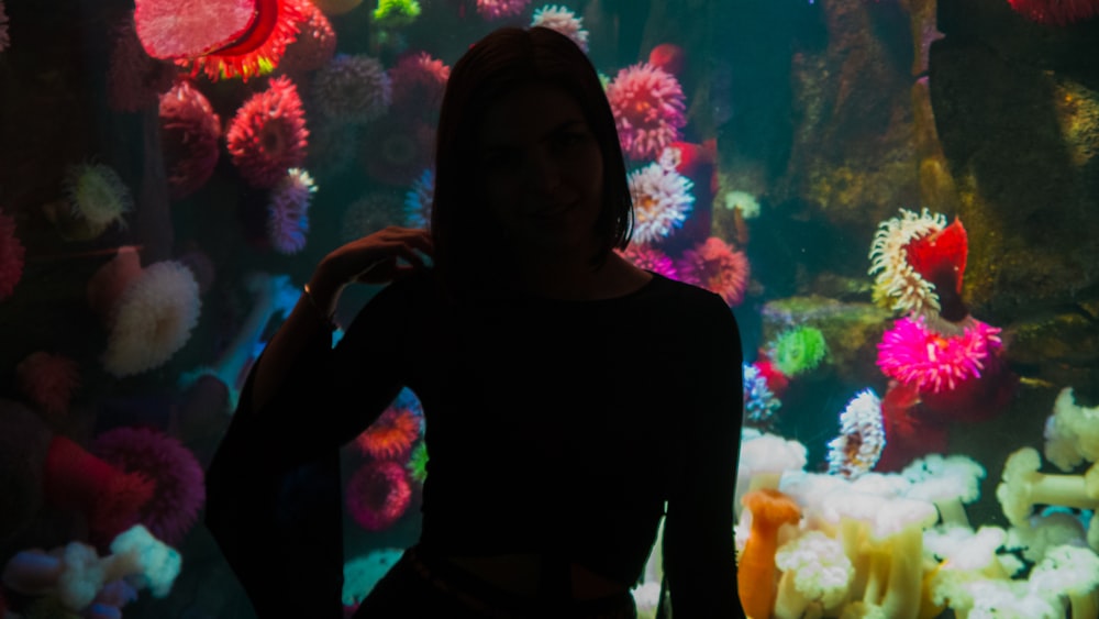 woman in front of aquarium low light photography
