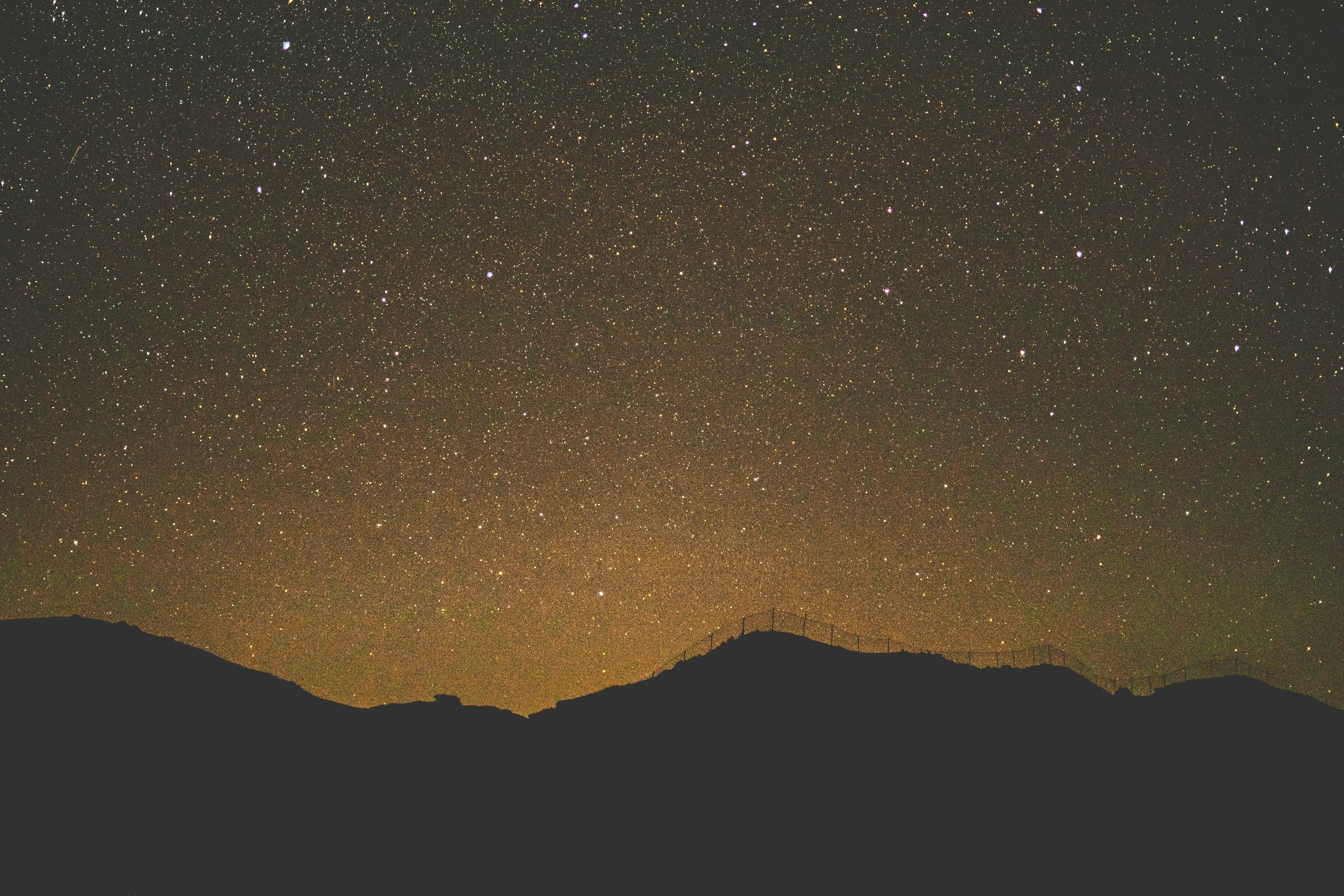 silhouette of mountain under starry night sky