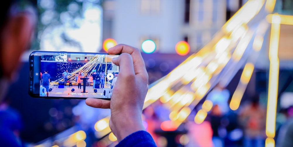 person taking picture of people beside lantern