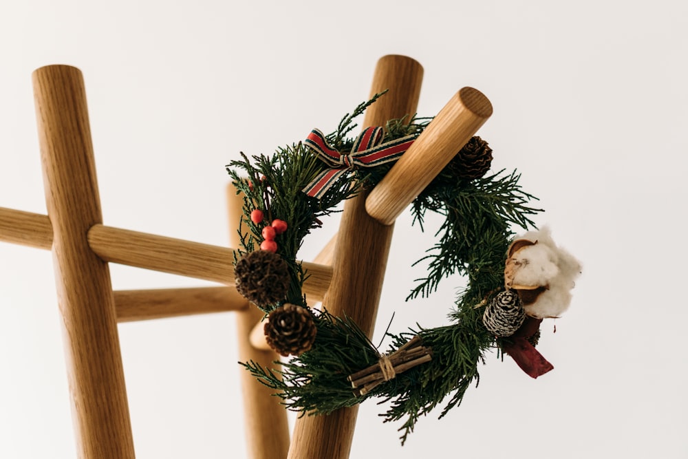 green and red tinsel and ribbon wreath hanged on brown wooden rack