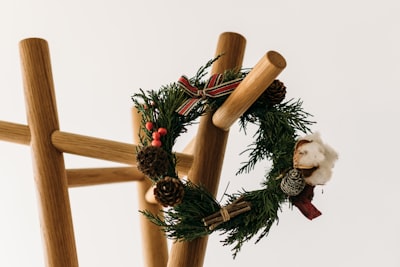 green and red tinsel and ribbon wreath hanged on brown wooden rack christmas tree stand zoom background