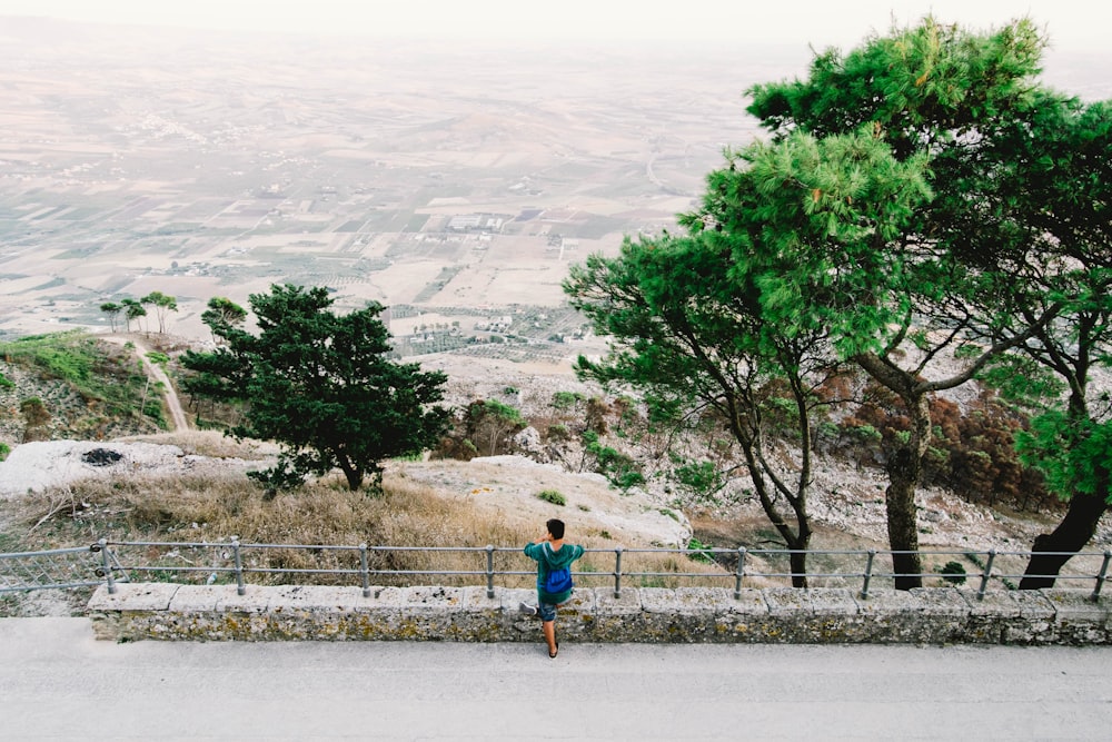 person standing on fence while looking below