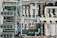 An aerial view of an industrial rooftop filled with various machinery and ductwork. The image features complex networks of pipes, large vents, and possibly HVAC units. The surfaces show signs of rust and wear, indicating age or exposure to the elements.