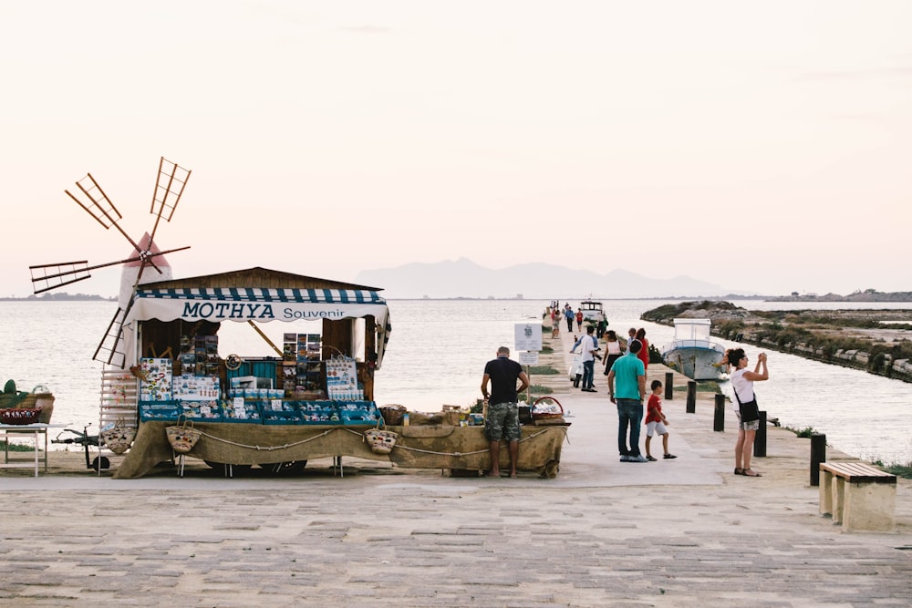 Personas de pie cerca del muelle y la tienda durante el día